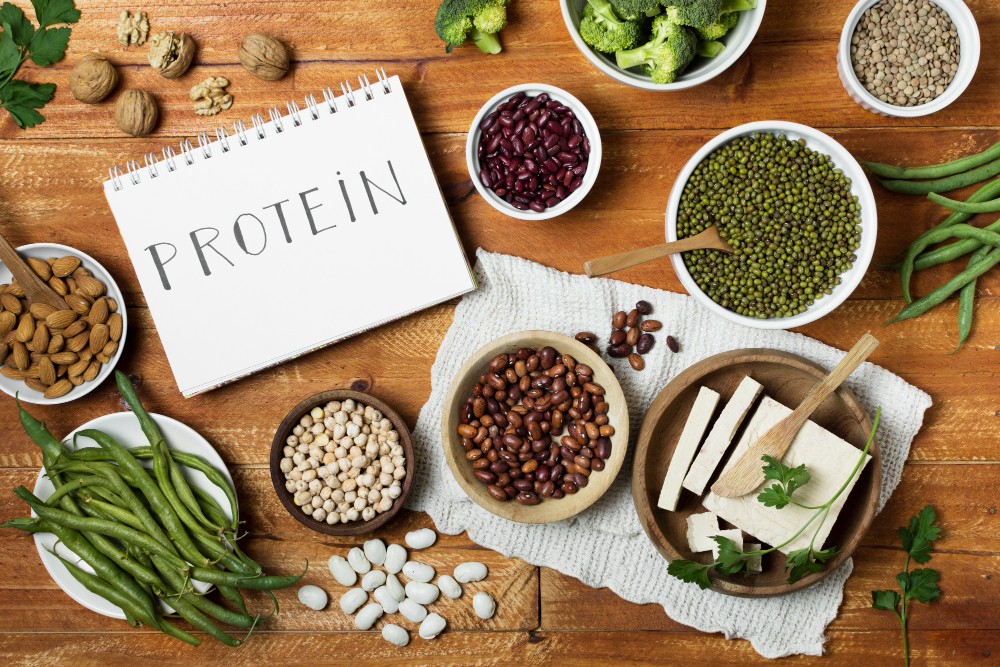 Assorted high-protein plant foods including lentils, tofu, and nuts on a kitchen counter